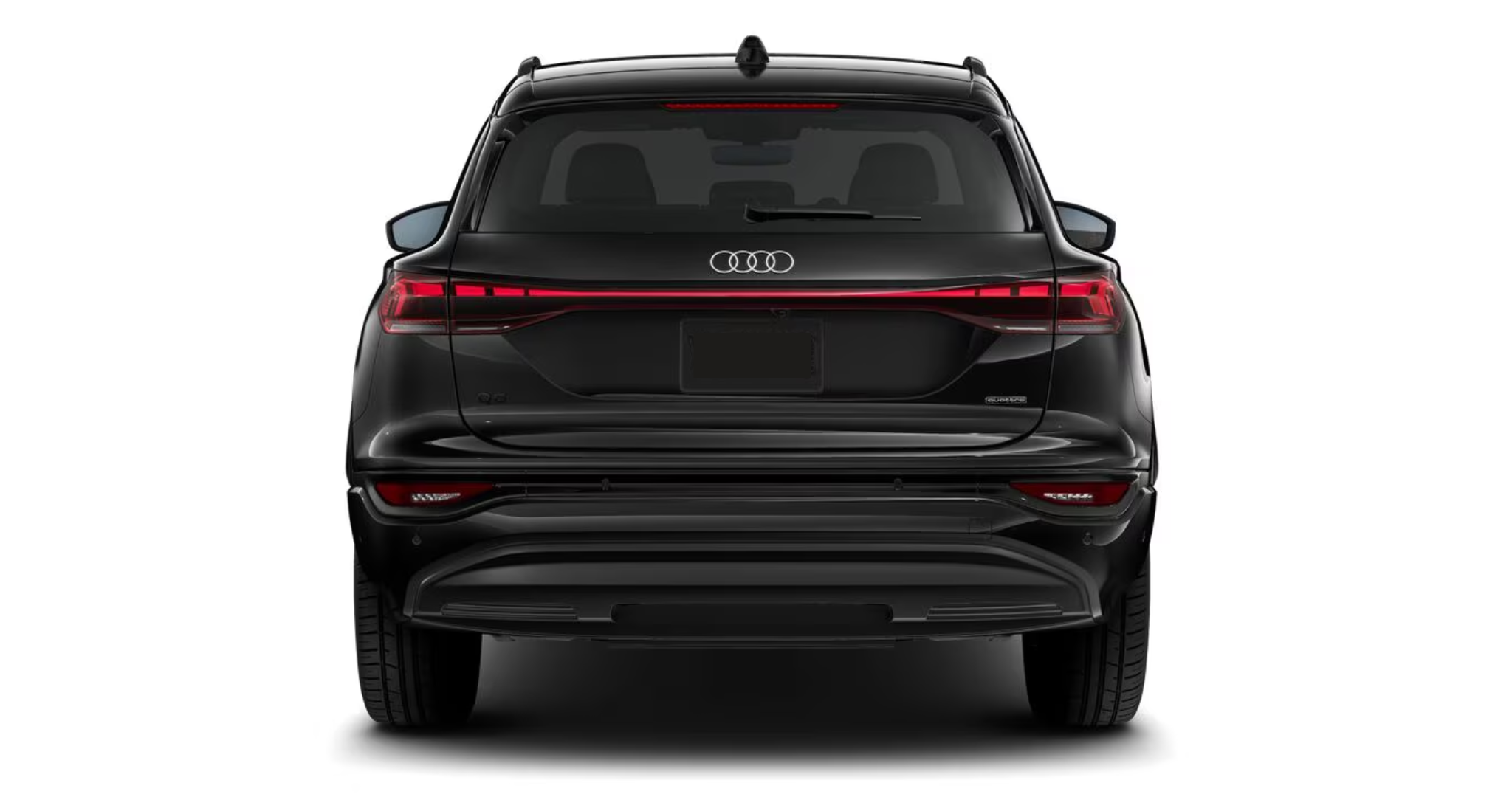 Rear exterior view of the 2025 Audi Q6 e-tron, highlighting sleek LED taillights, a sculpted bumper, and a futuristic all-electric SUV design.