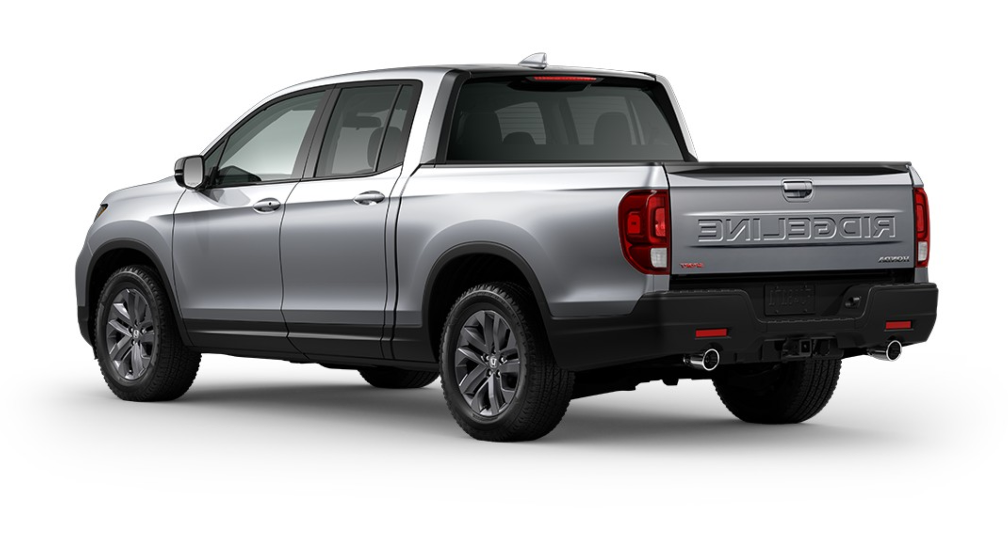 Rear angle of the 2025 Honda Ridgeline Sport, highlighting the tailgate, dual exhaust outlets, and Ridgeline branding embossed on the bed.
