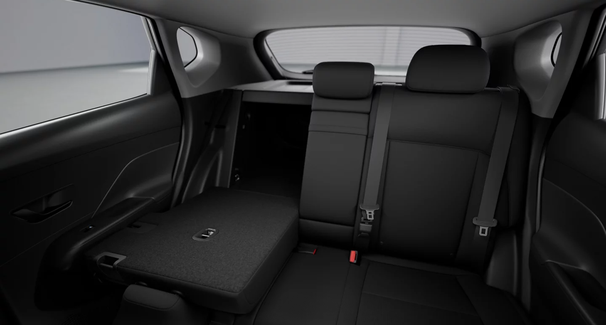 2025 Hyundai Kona Electric SE rear seats with one seat folded flat, showcasing flexible cargo space and black cloth upholstery.