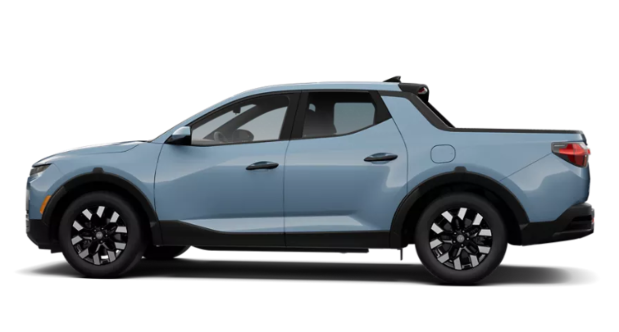 Side profile view of the 2025 Hyundai Santa Cruz SE in light blue, highlighting its compact pickup truck design, aerodynamic lines, and 18-inch alloy wheels.