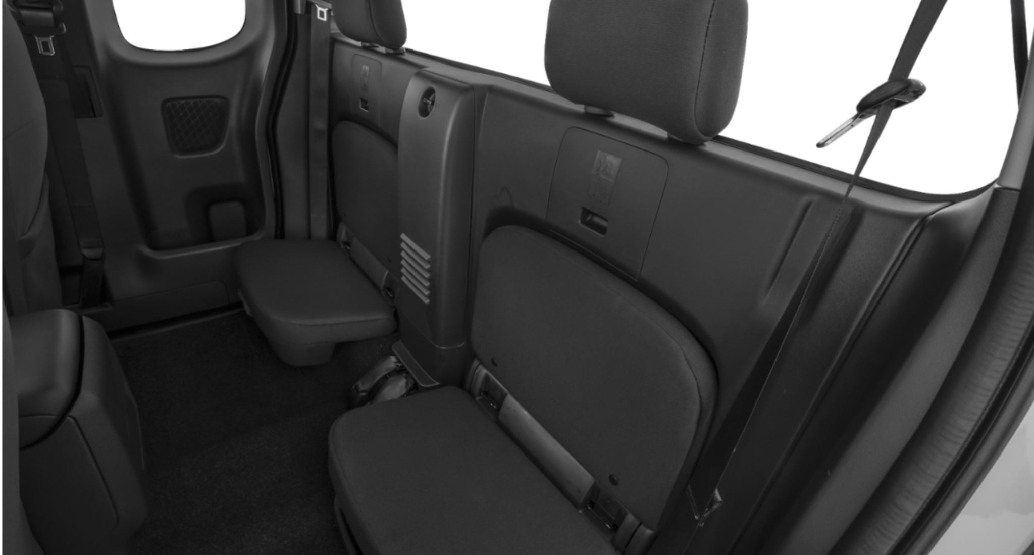 Interior view of the 2025 Nissan Frontier King Cab S 4x2 rear seats featuring foldable bench seating with cloth upholstery and compact storage space.