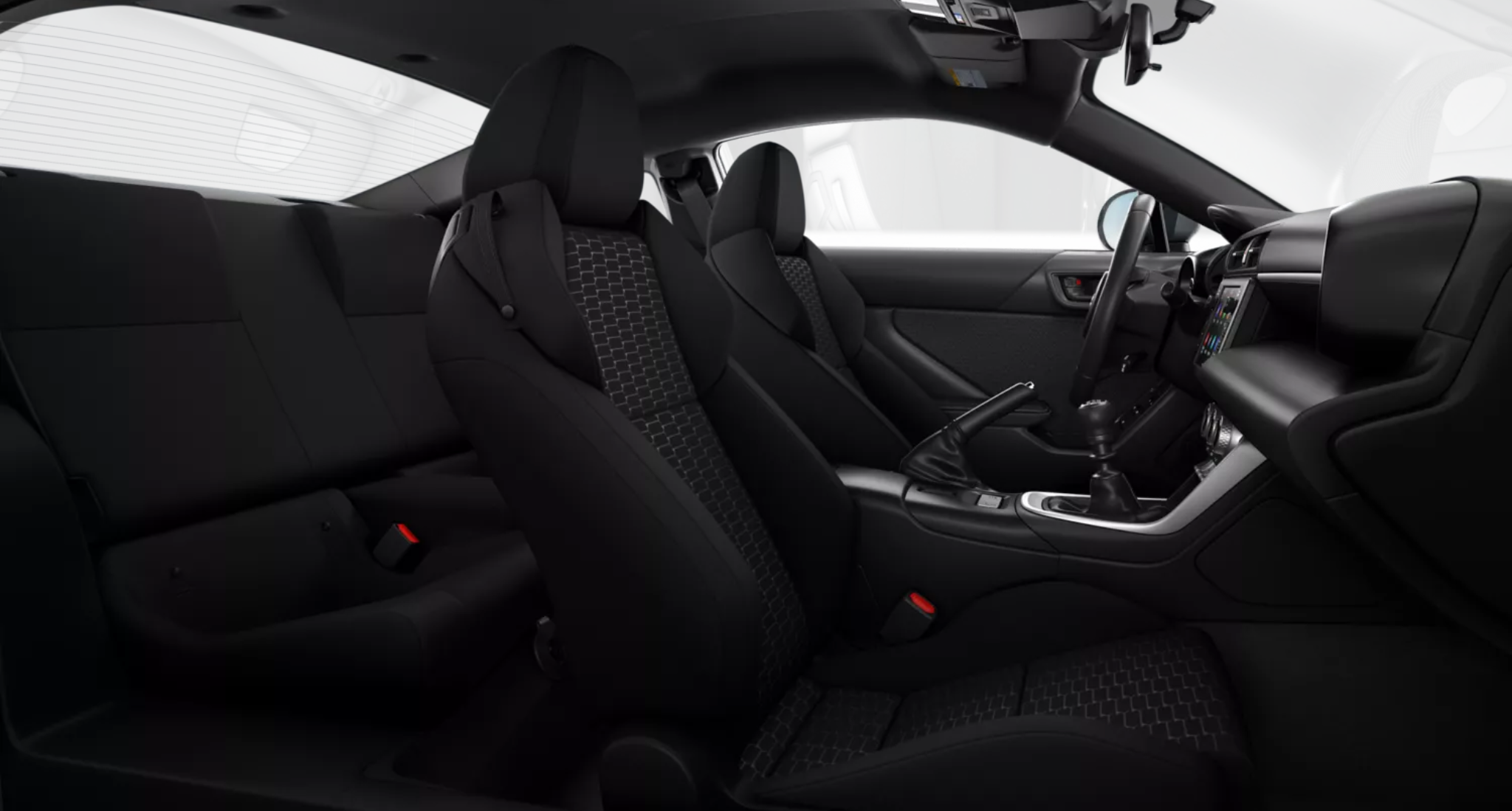 2025 Toyota GR86 interior view showcasing black sport bucket front seats with G-embossed inserts and rear passenger seating, emphasizing comfort and racing-inspired design.