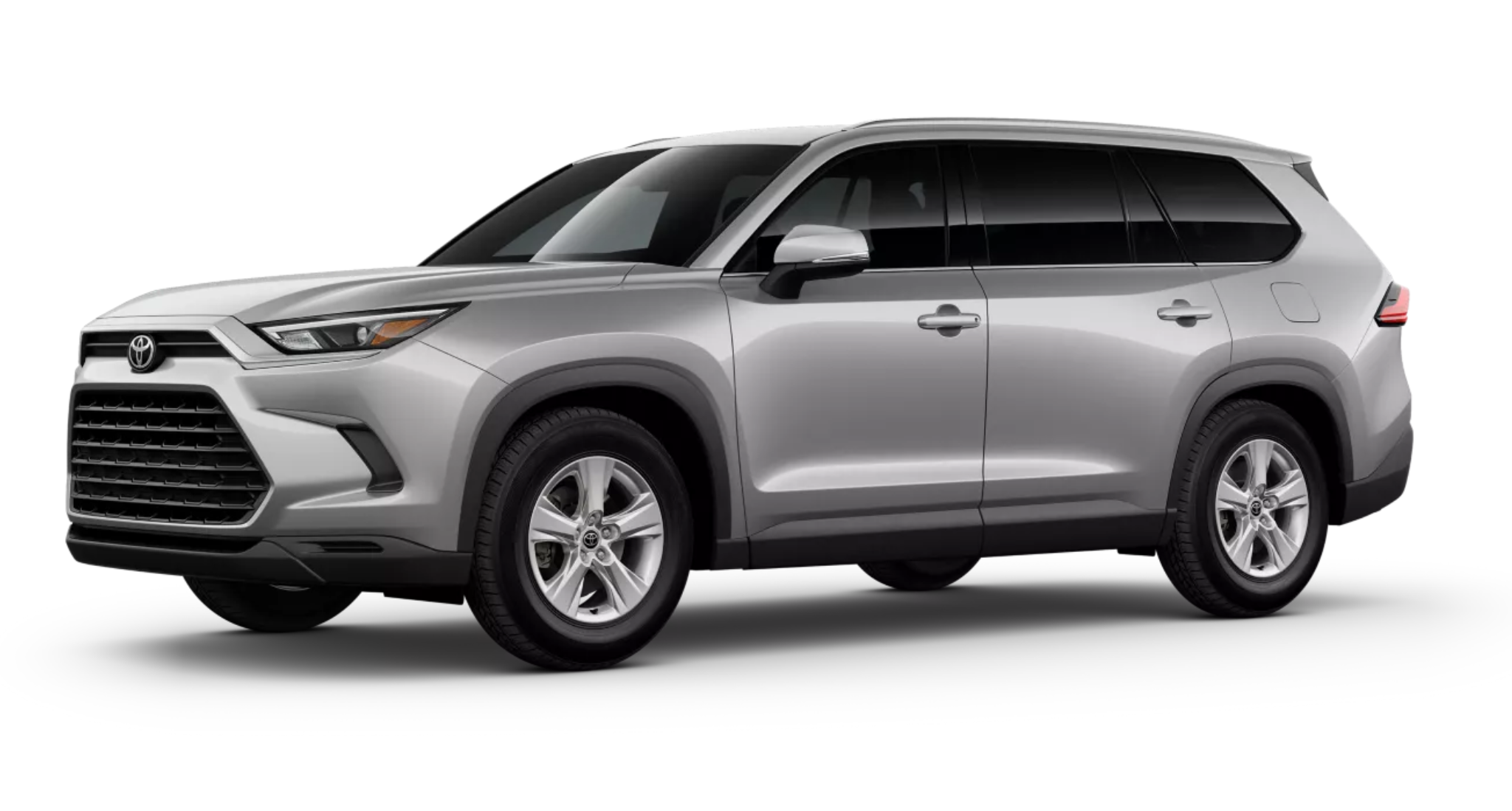 Angled side profile of the 2025 Toyota Grand Highlander LE in silver, showcasing its sleek body lines, alloy wheels, and spacious SUV dimensions.