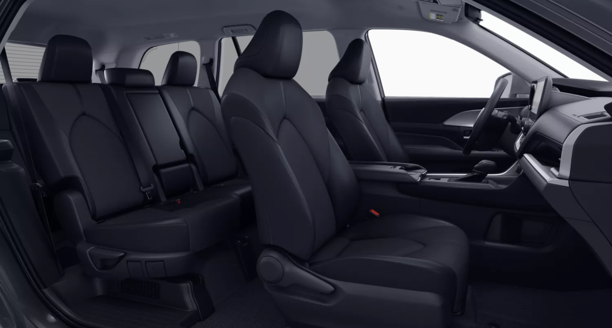 2025 Toyota Grand Highlander Hybrid LE AWD interior view showing three rows of seating with black fabric upholstery and spacious cabin layout.
