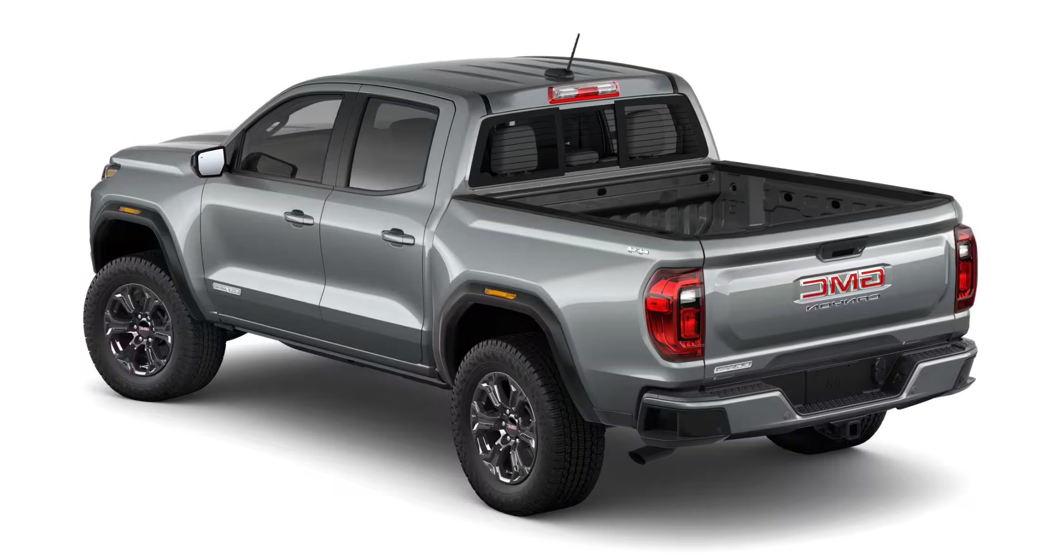 Rear view of the 2025 GMC Canyon Elevation 4X4 in silver, highlighting the bed design, rear bumper, and tailgate branding.