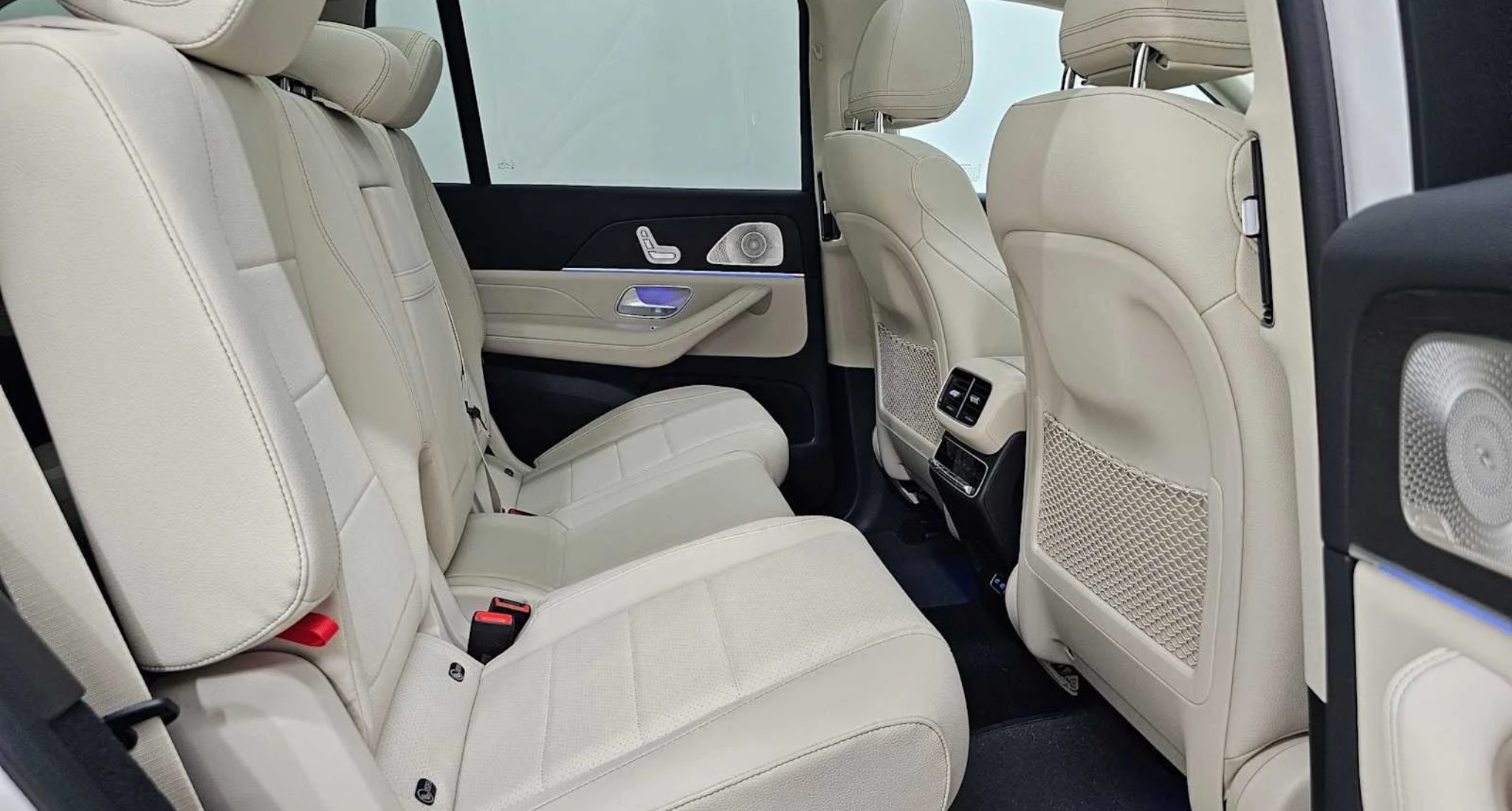 2025 Mercedes-Benz GLS 450 SUV second-row seating with beige leather upholstery, ambient lighting, and premium door controls