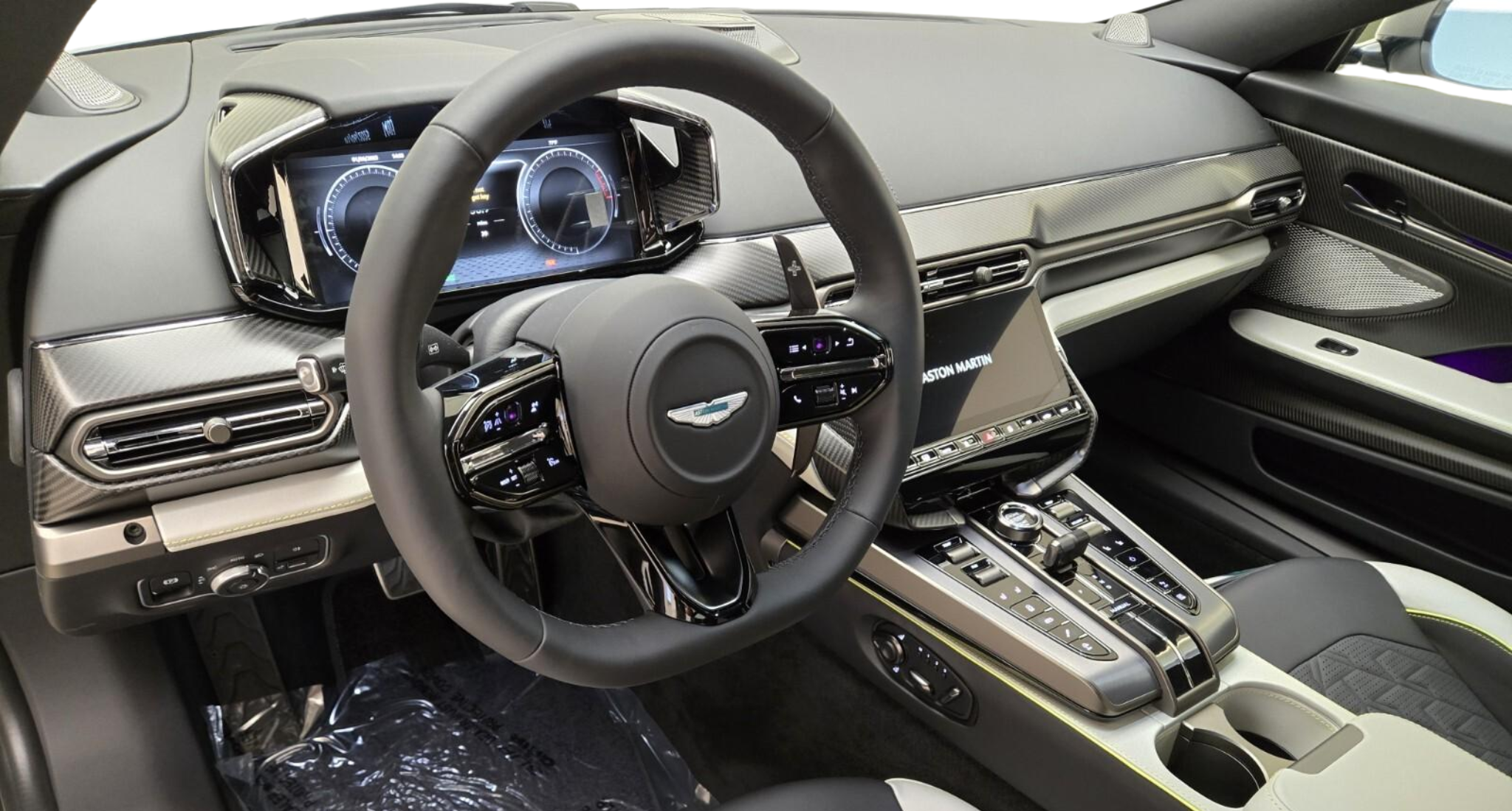 Digital driver display and carbon fiber dashboard of the 2025 Aston Martin Vanquish featuring advanced infotainment and performance controls.