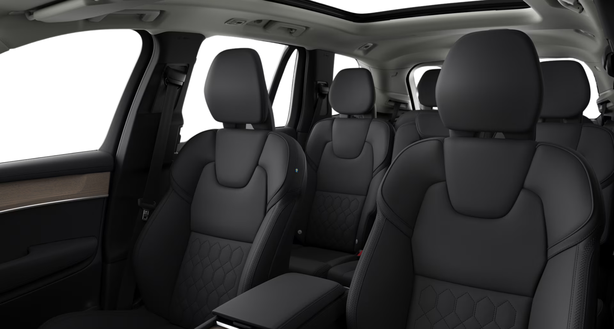 Interior view of the 2025 Volvo XC90 PHEV AWD featuring three-row black quilted seats and panoramic roof.