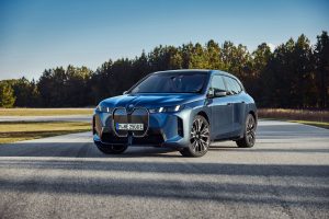 2026 BMW iX Review: Front view of luxury electric SUV with illuminated kidney grille.